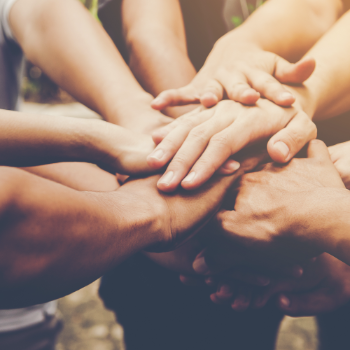 People with their hands put on top of each other - sign of teamwork